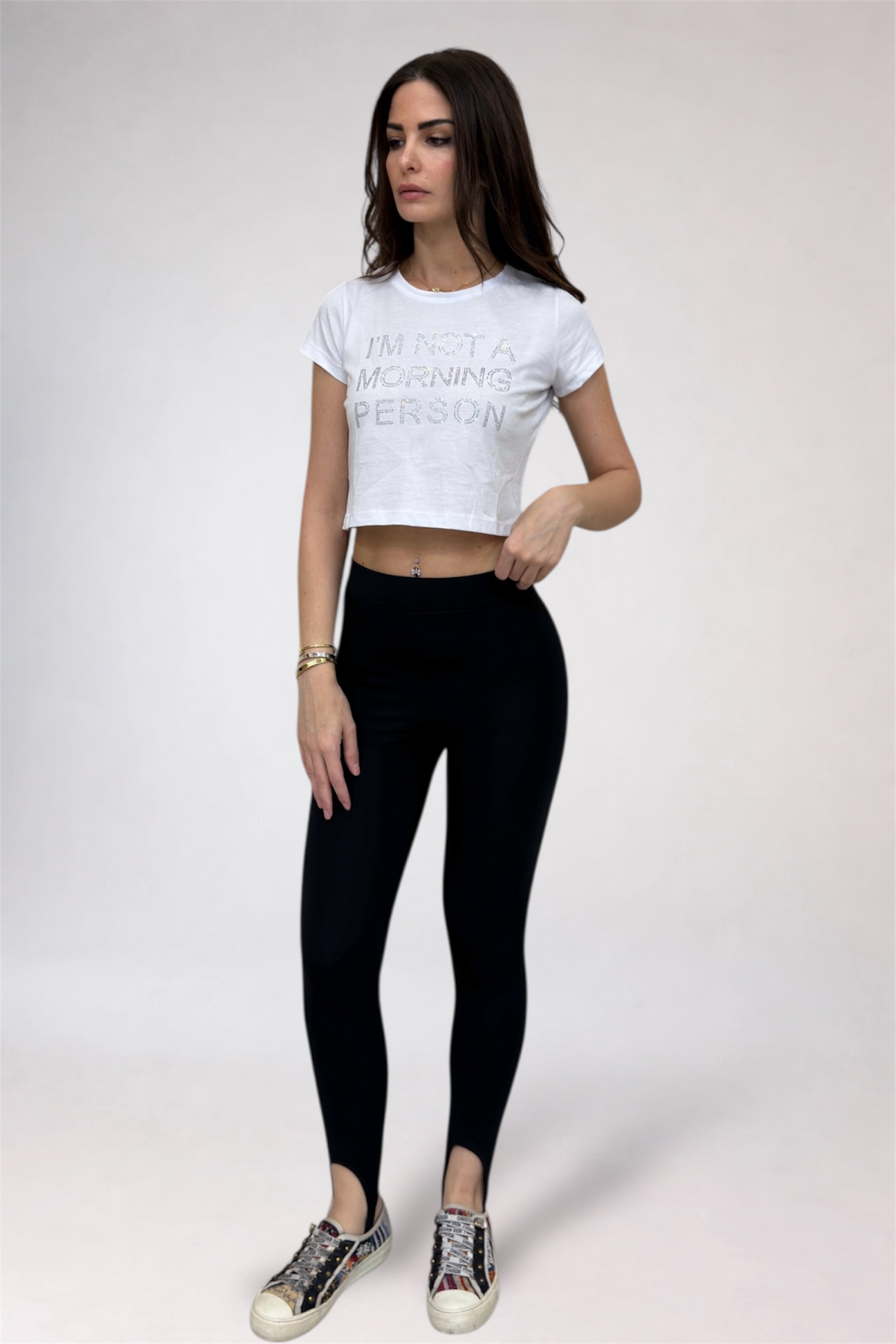 Woman wearing a white t-shirt with text and black leggings on a white background