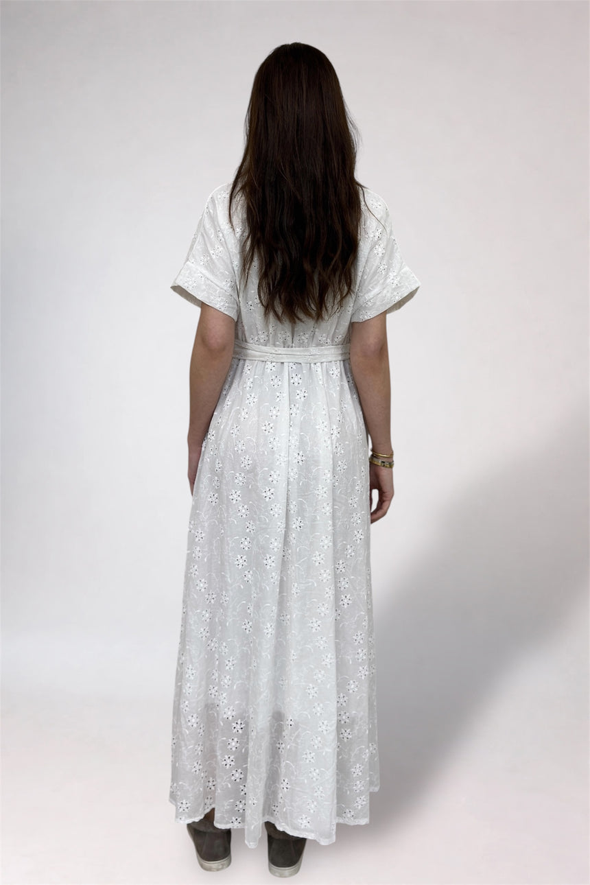 Woman wearing a white lace dress from behind on a plain background