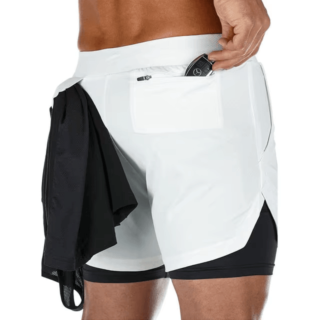 White athletic shorts with black accents worn by a person, with a black shirt draped over one shoulder.