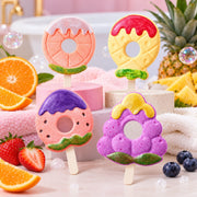 Fruity bath bomb lollipops – orange, pineapple, strawberry and grape inspired designs on pastel spa display