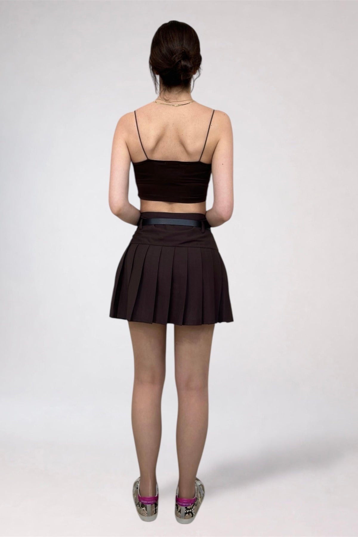 Person wearing a black top and skirt on a white background