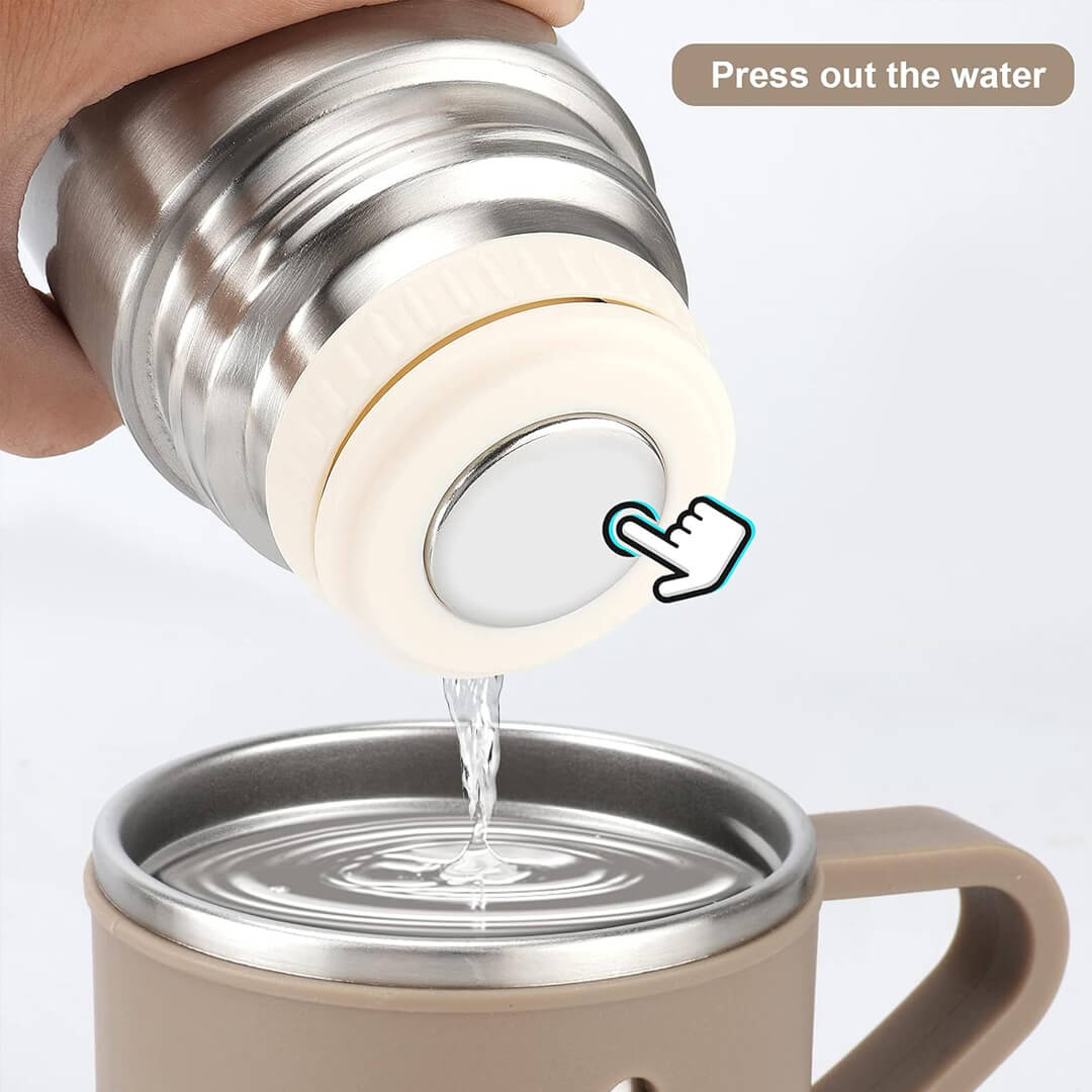 Stainless steel travel mug with a lid being opened to press out water.