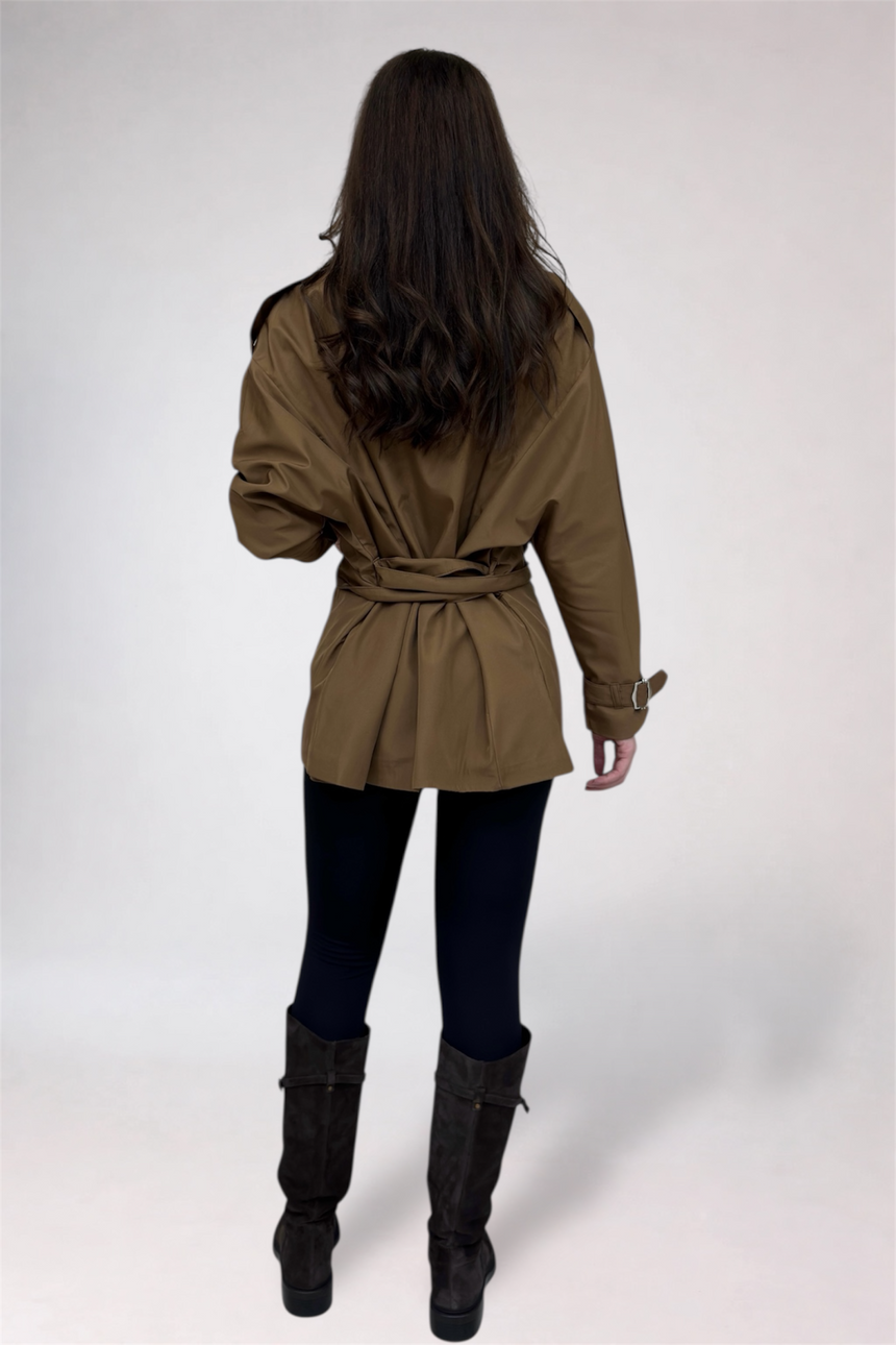 Woman wearing a beige trench coat on a white background