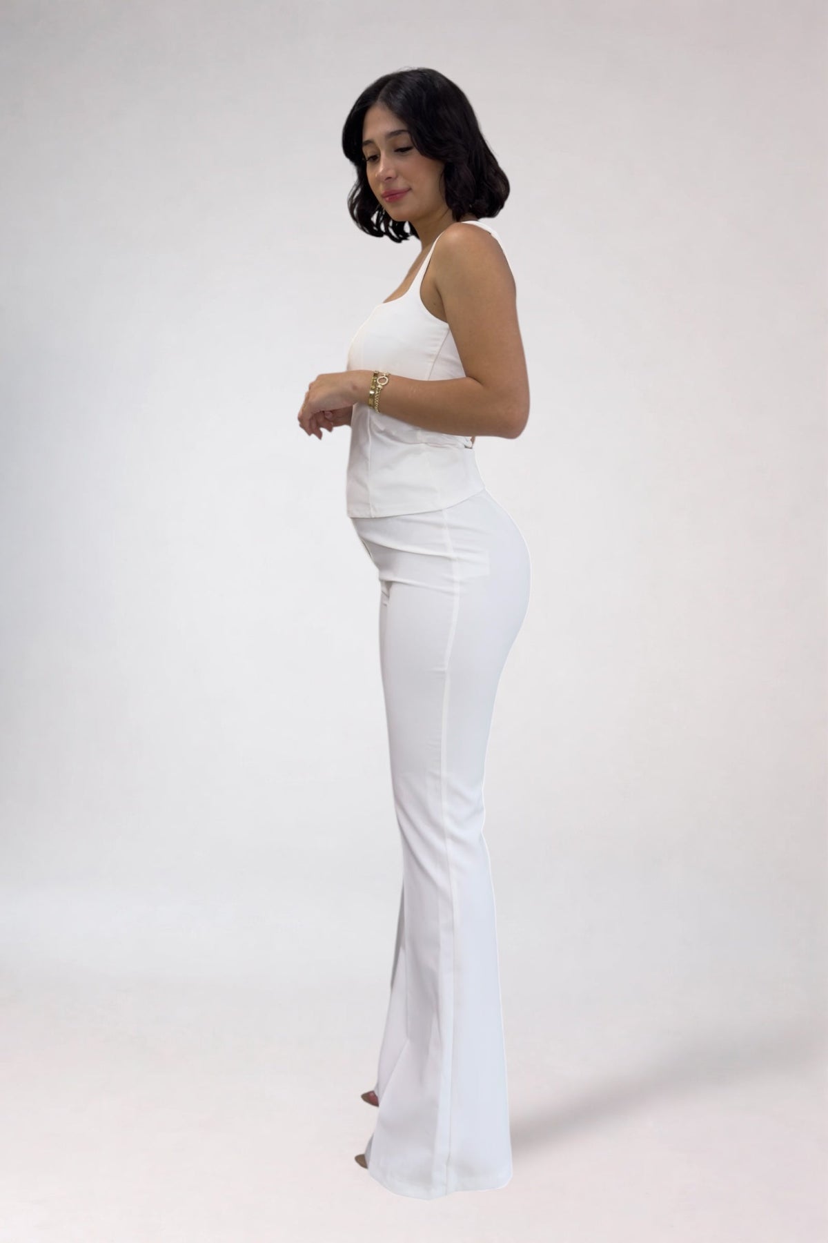Woman wearing a white dress against a plain background