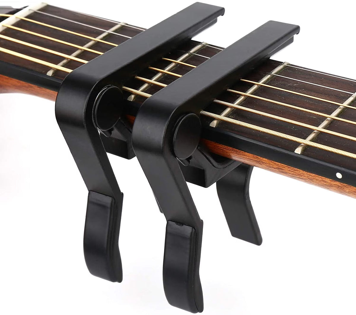 Black guitar capo on an acoustic guitar with a white background