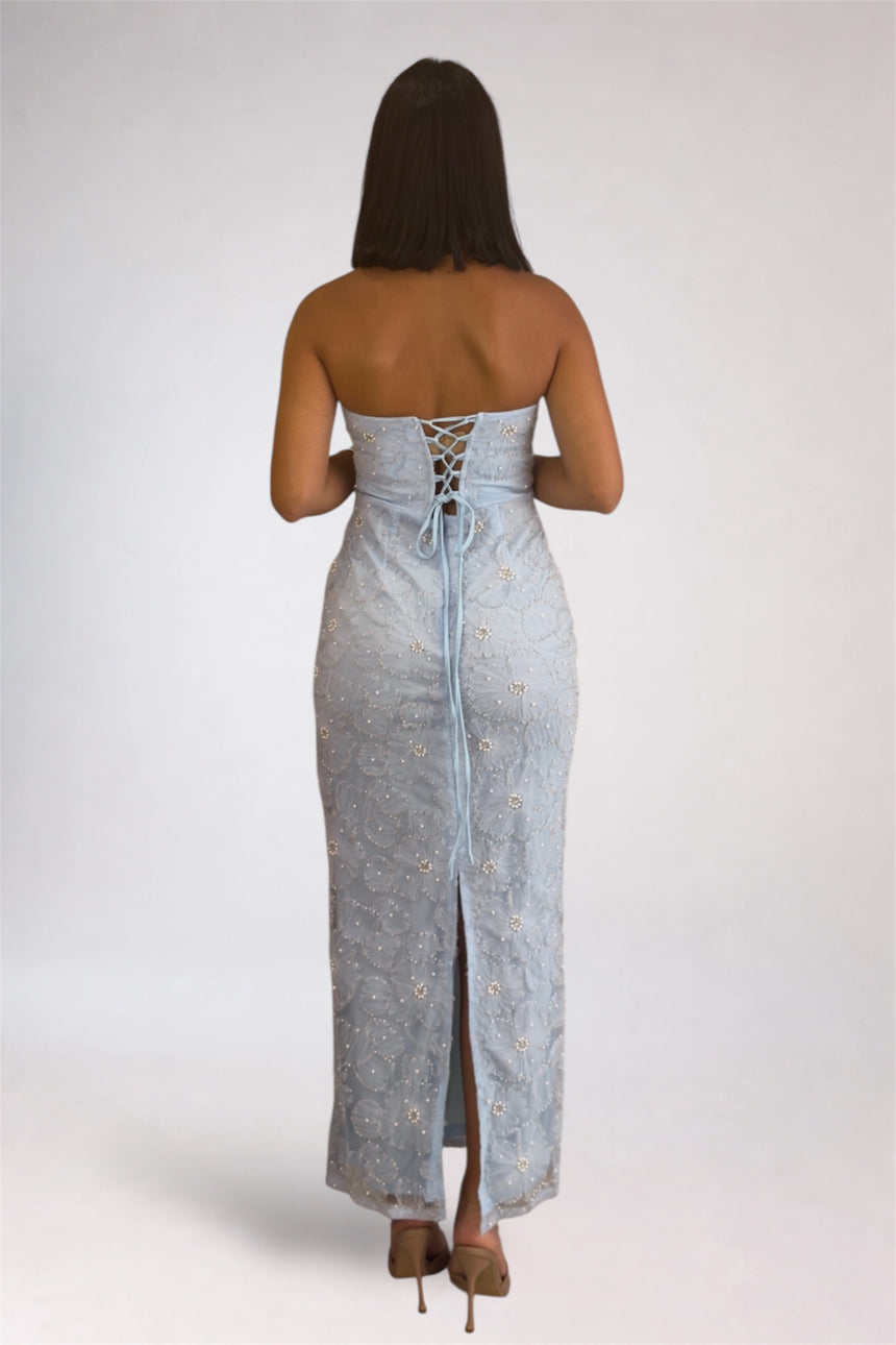 Woman wearing a strapless denim dress with lace-up back on a white background