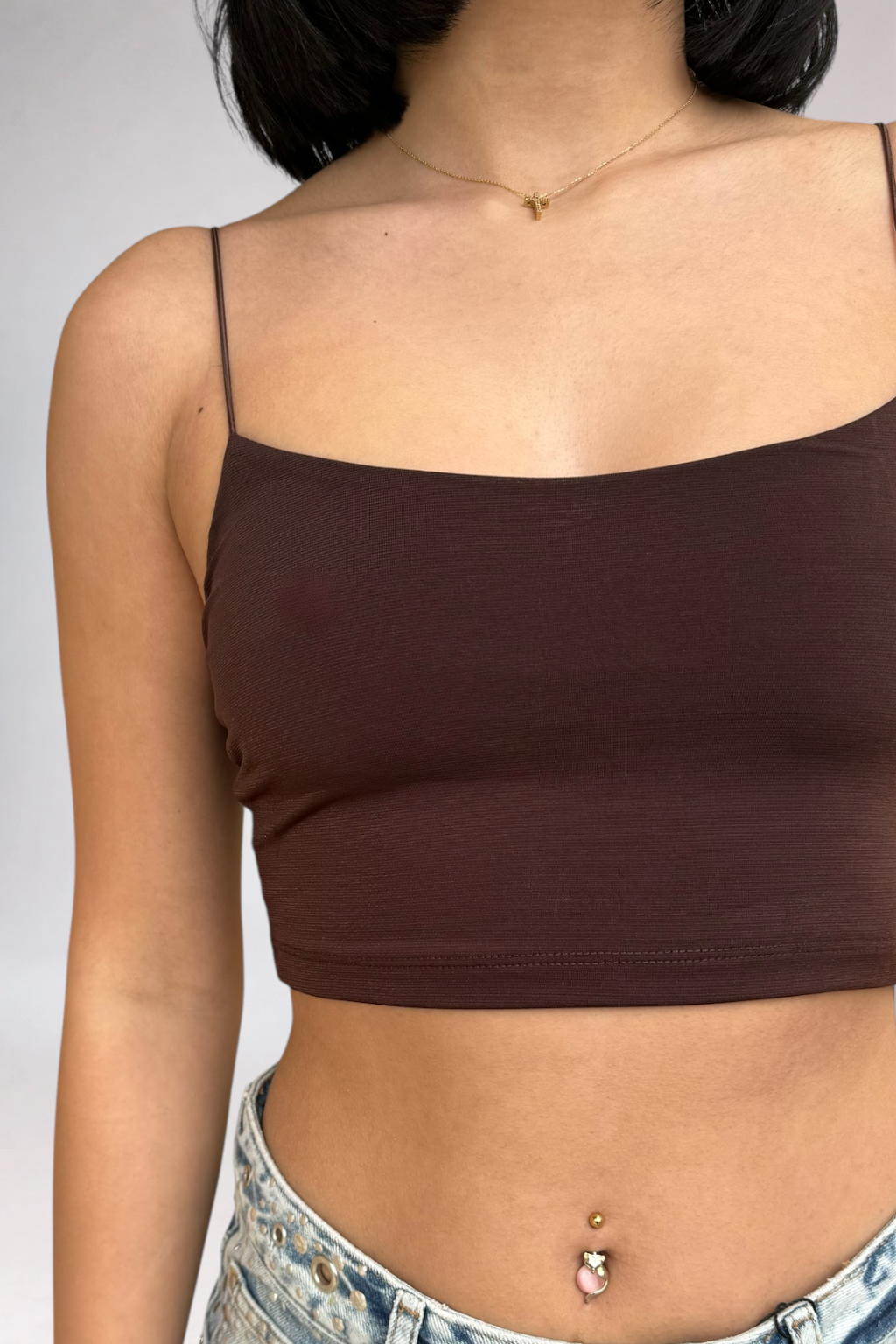 Brown crop top worn by a person on a plain background