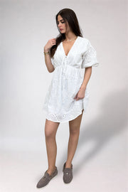 Woman wearing a white dress with a plain background