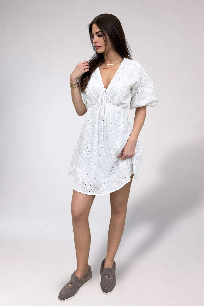 Woman wearing a white dress with a plain background