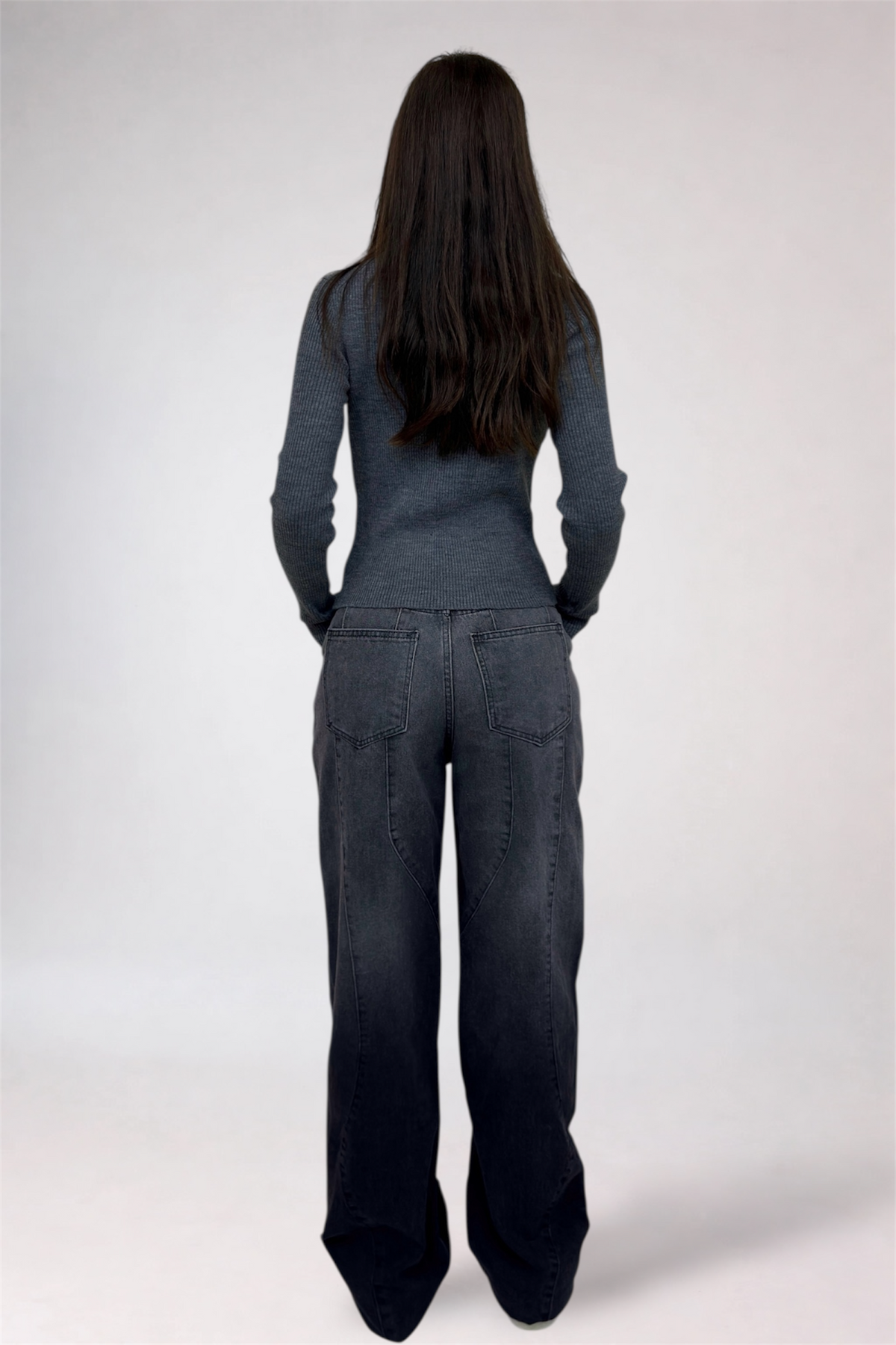 Person wearing a gray jumpsuit on a white background