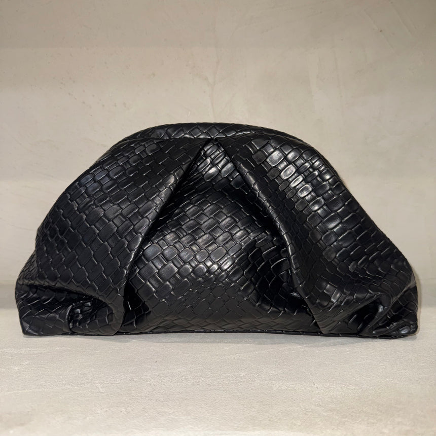 Black textured clutch bag on a light beige background