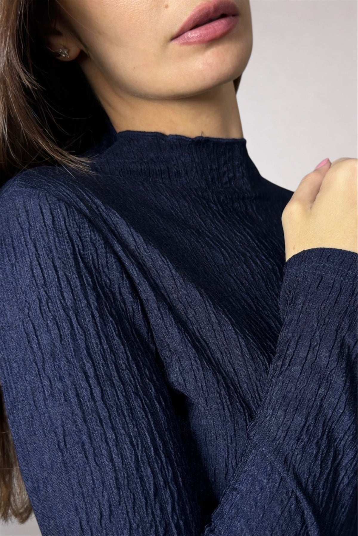 Navy blue ribbed sweater worn by a person with a neutral background