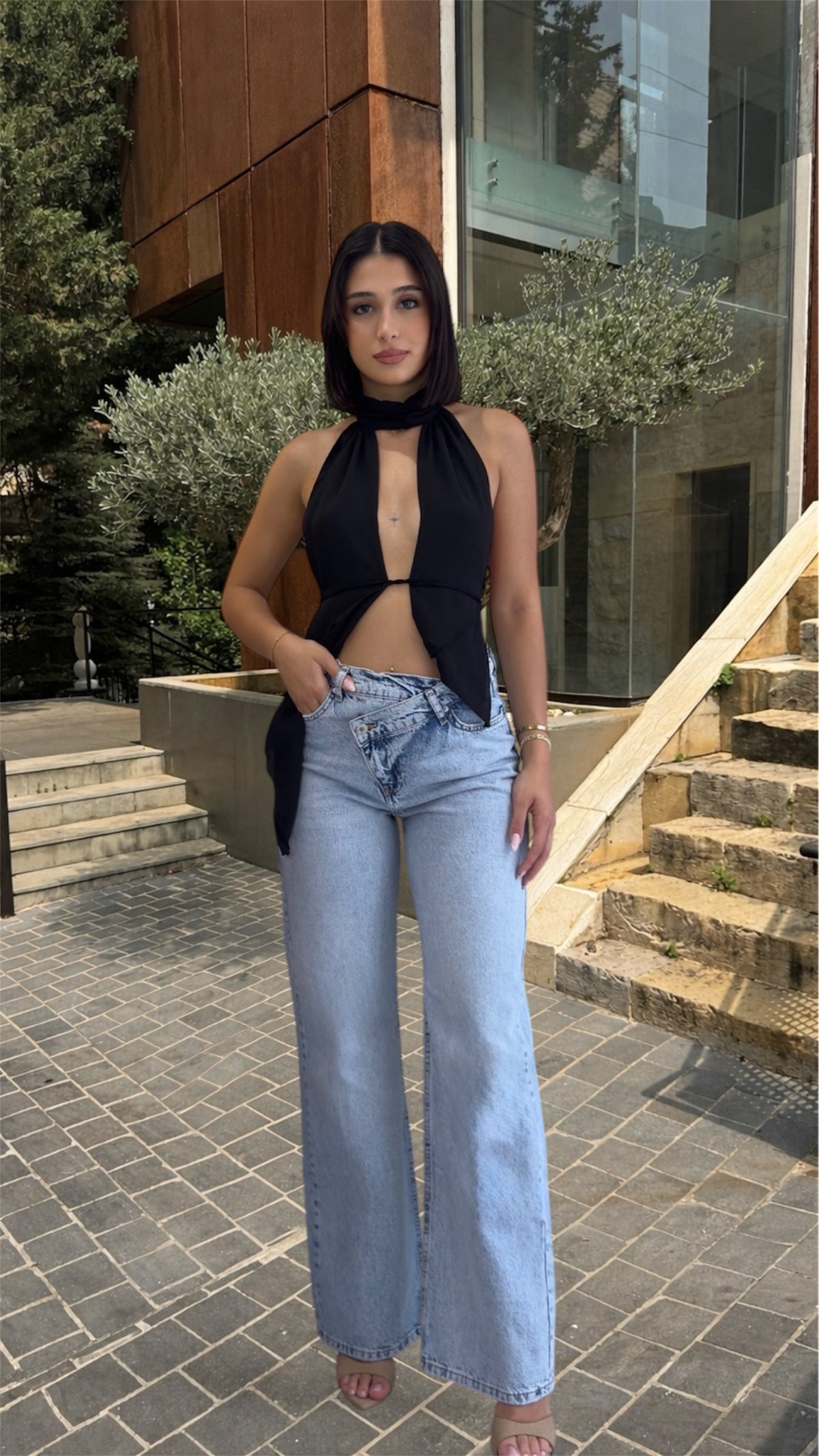 Woman wearing a black halter top and light blue jeans 