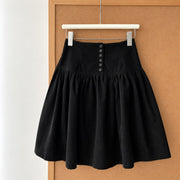 Black corduroy A-line skirt with decorative buttons, front view
