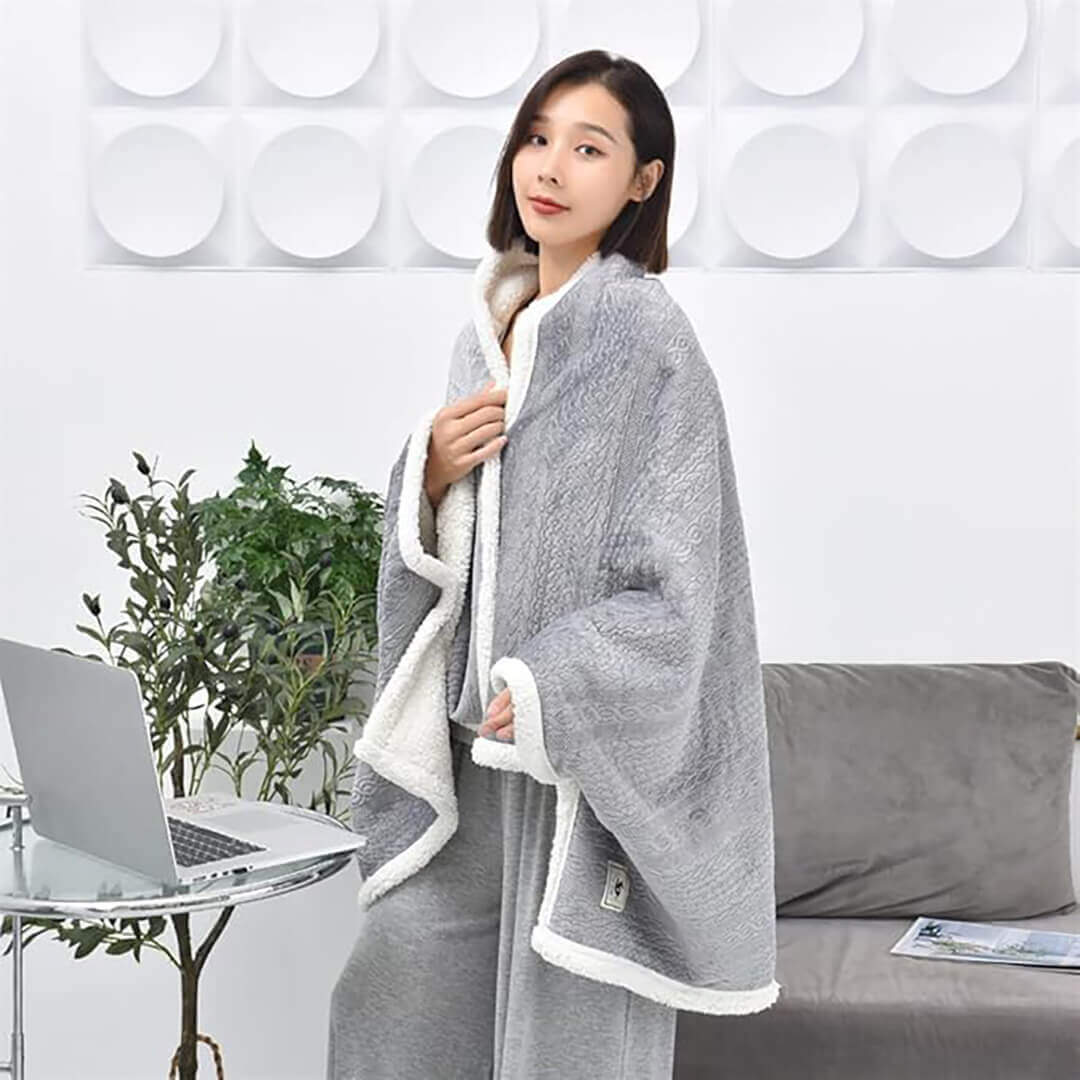 Woman wrapped in a gray blanket with button.