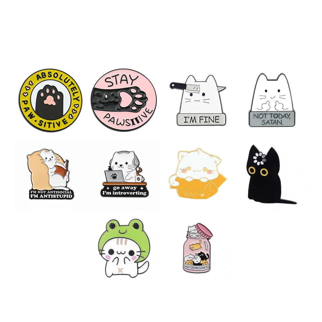 A set of ten cute cartoon cat enamel pins arranged on a plain white background. The designs include various expressions and scenes such as a black cat with a flower, a white cat reading, a black cat with a sign, a green frog hood, and a cat inside a jar.
