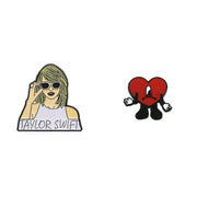 Two enamel pins on a white background, one featuring a person with sunglasses and the other a red heart character.