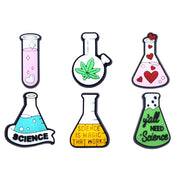 A collection of six Chemistry-themed Jibbitz charms for Crocs, featuring various chemical symbols and elements such as a beaker, an atom, and a periodic table.