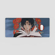Desk Mat with anime character reading a book and red flowers on a blue background