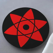 A black and red Naruto Sasuke's Mangekyou Sharingan coaster on a white surface.
