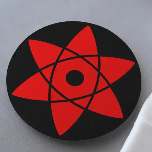 A black and red Naruto Sasuke's Mangekyou Sharingan coaster on a white surface.