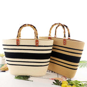 Two straw bags with black stripes and bamboo handles 