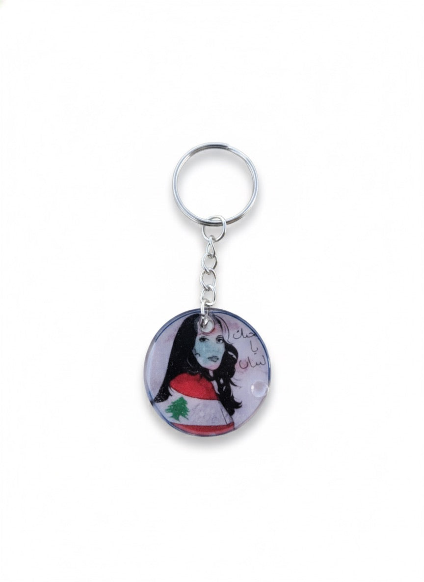 Keychain with a circular design featuring a character and text on a white background