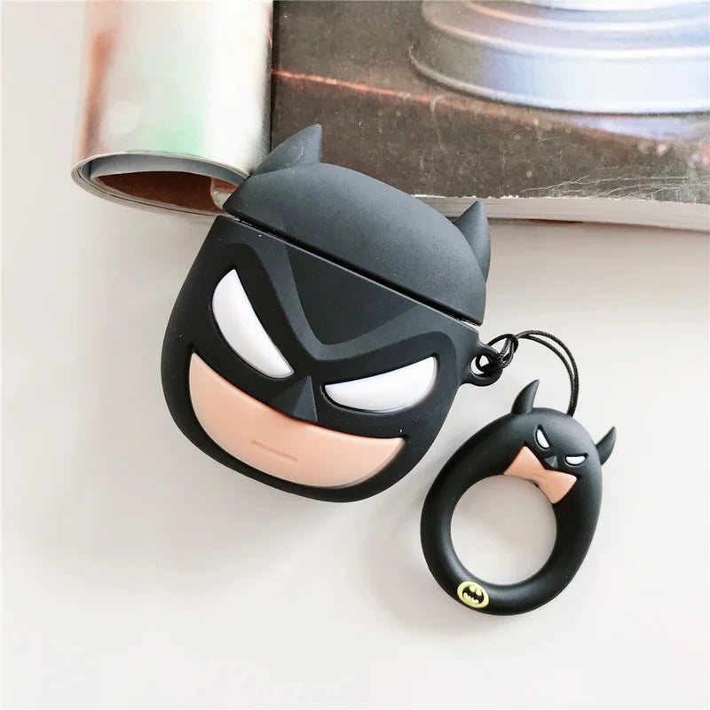 Black bat-themed airpod case and keychain on a white surface