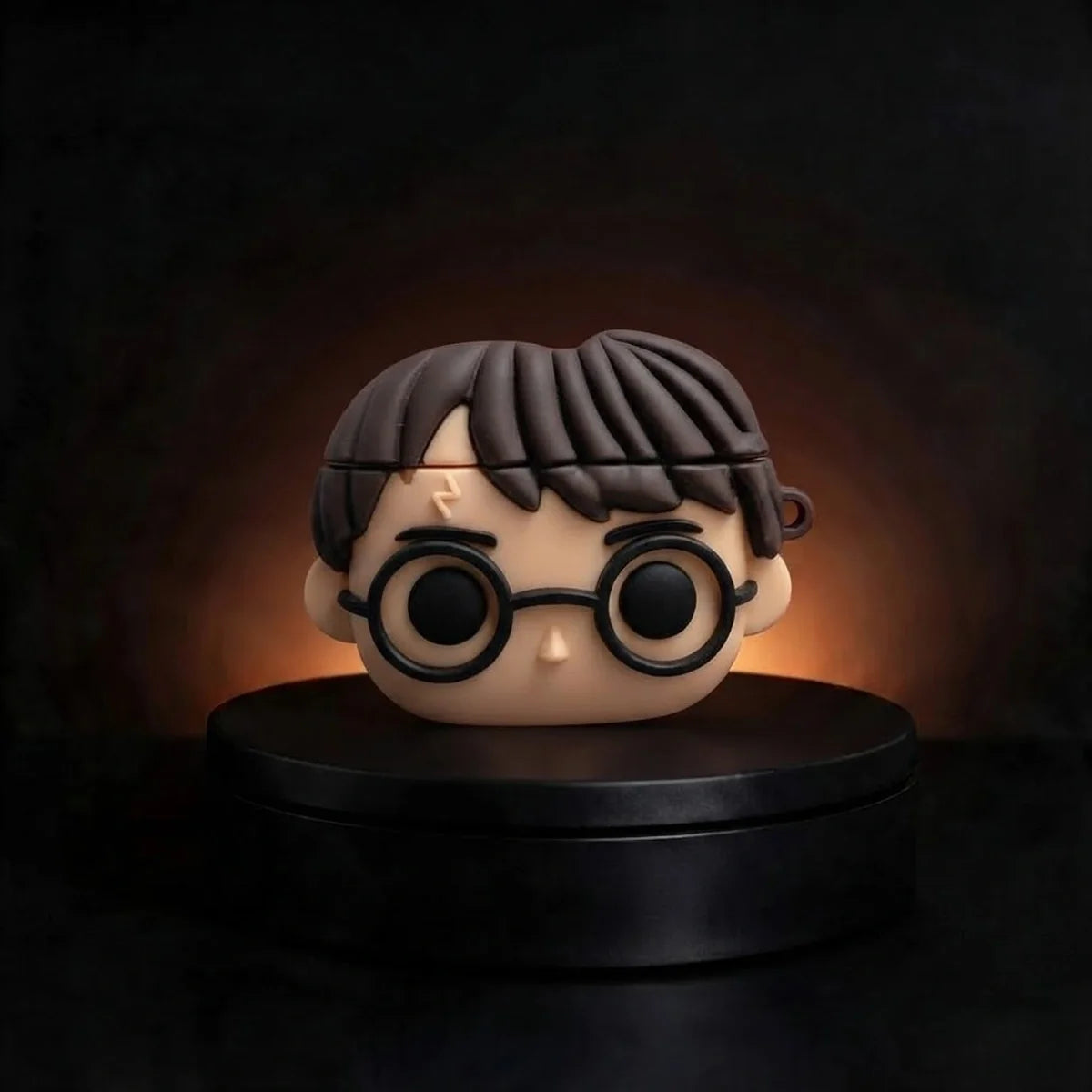 A stylized collectible figure of harry potter case for airpods with round black glasses and dark hair, displayed on a black circular pedestal against a dark background with a warm glow behind the head.