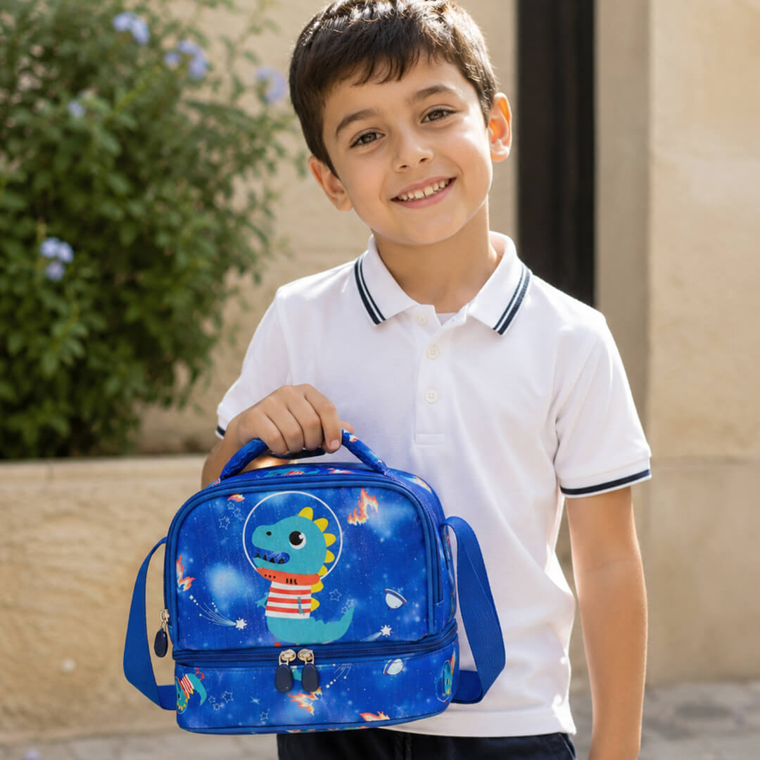 Boy holding a blue dinosaur lunch bag with a dino-themed print. 