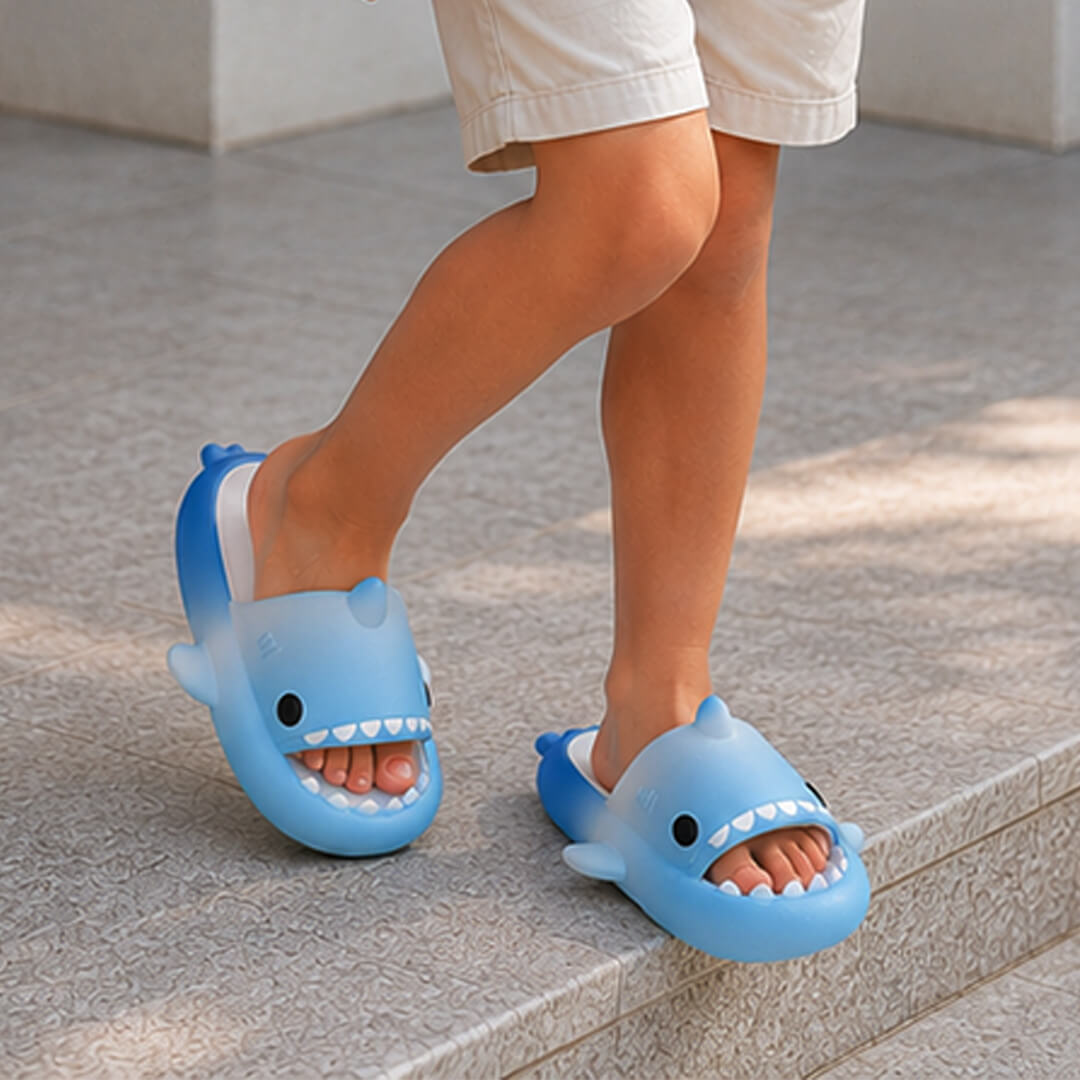 Children's feet wearing blue shark-shaped sandals slipper