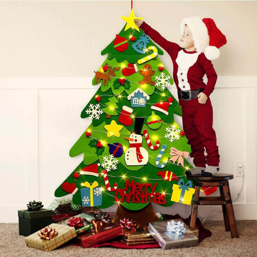Child placing candy cane ornament on felt Christmas tree
