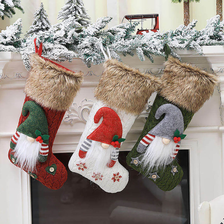 Three Christmas stockings with gnome designs in red, green and white colors.