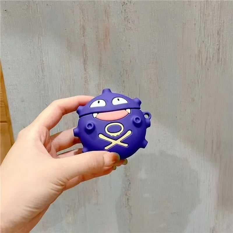 Hand holding a purple cartoon character air pod case against a light wooden background