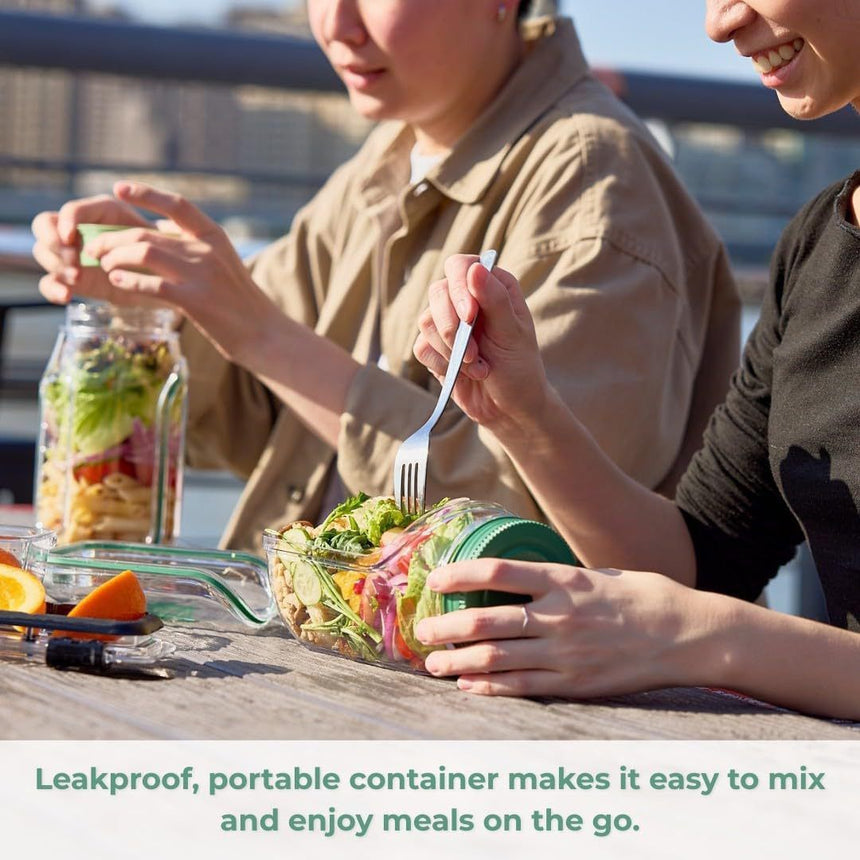 2 people eating salad on a table using the leak-proof salad jar with side opening