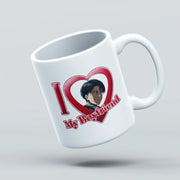 A white ceramic coffee mug with a printed graphic that reads 'I [heart] My Boyfriend' with an anime-style character portrait inside the heart, shown floating against a light gray background.