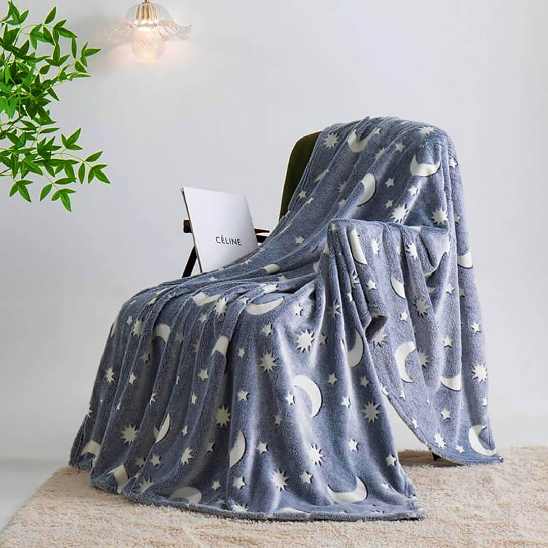 Stars and moons glow blanket in dark navy.