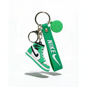 Green Nike keychain with shoe and strap design on a white background