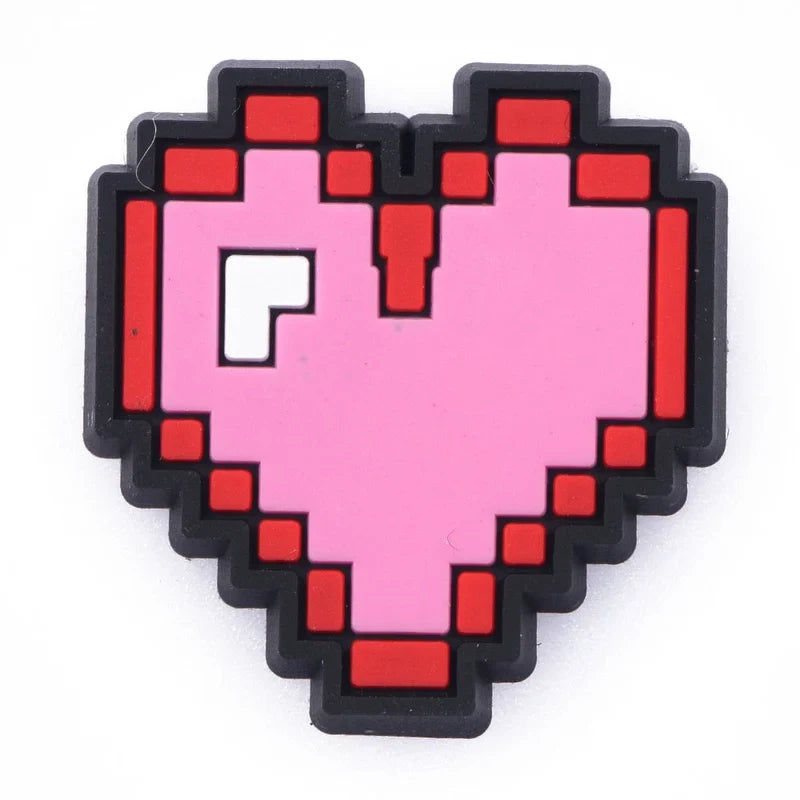 Pixelated heart-shaped croc charm with a pink center and red outlines on a white background