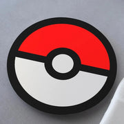 A coaster with a colorful pokemon pokéball design on it, placed on a white surface.