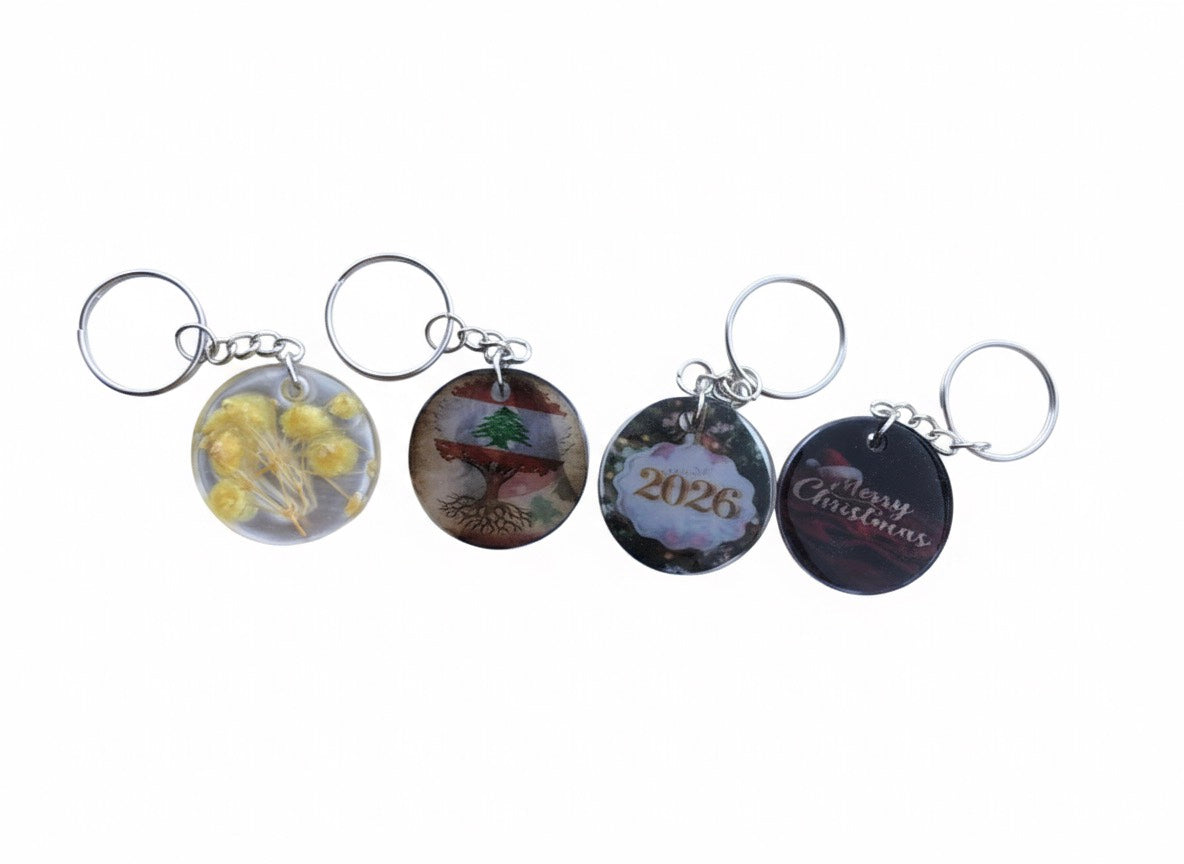 Four keychains with different designs on a white background