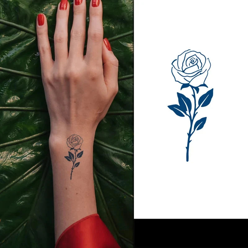 Hand with rose tattoo on wrist against green leaves