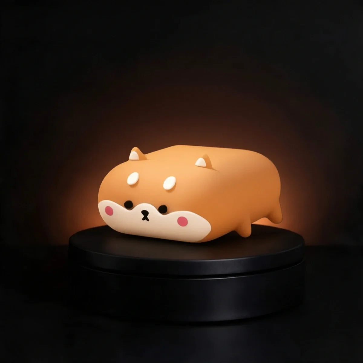 A cute, cartoonish orange shiba inu airpods case with a cream-colored face, resting on a black circular rotating display base against a dark background.