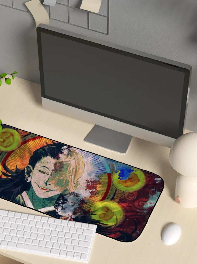 Colorful mouse pad with artistic design on a desk with a computer setup.