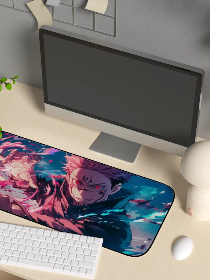 Desk setup with a computer monitor, keyboard, and mouse on a desk mat featuring anime character Sukuna from Jujutsu Kaisen.