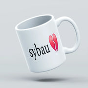 White mug with 'sybau' text and red heart design on a light gray background