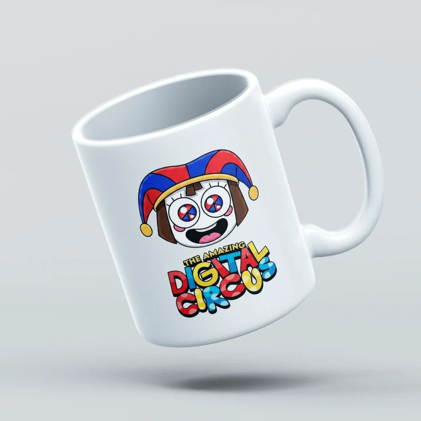 A white ceramic coffee mug with a colorful cartoon jester face and the text 'The Amazing Digital Circus' printed on it, shown floating against a light gray background.