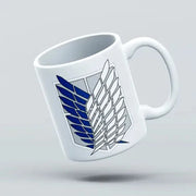 A white ceramic mug with a blue and gray wings of freedom design, flipped upside down on a plain background.